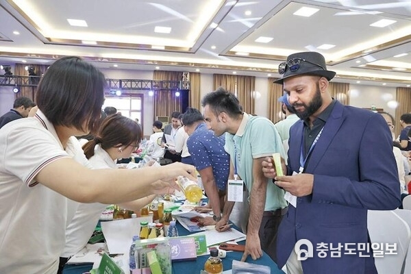 Photo shows that a Pakistani merchant tasted apple vinegar at an exhibition stand during the international procurement event held in Longkou City of east China's Shandong Province recently. (Source: Longkou/Liu Qiqiang)
