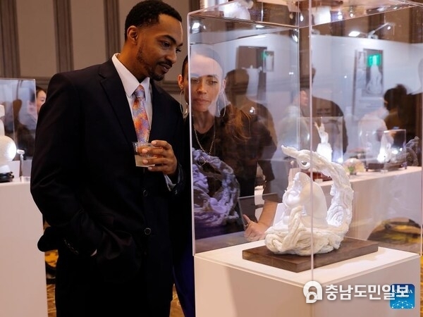Visitors view an artwork at an exhibition showcasing China's Dehua white porcelain in Los Angeles, the United States, Nov. 21, 2025. The exhibition opened here Friday, drawing over 100 attendees from both countries and aiming to highlight traditional Chinese culture while promoting cross-cultural exchange. Titled "The Aesthetics of Harmony: Blanc de Chine, Porcelain from Dehua," the exhibition featured around 100 finely crafted ceramic artworks and photographic pieces. (Photo by Qiu Chen/Xinhua)