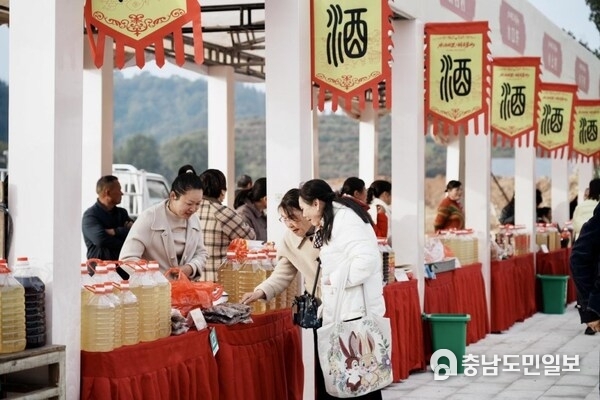 The photo shows that visitors are tasting local wine at the annual culture festival held in Mengshan Town in east China's Jiangxi Province.