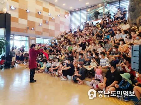 서산버드랜드 여름방학 특별프로그램 참가자들이 철새전시관 1층로비에서 마술공연을 관람하고 있다,
