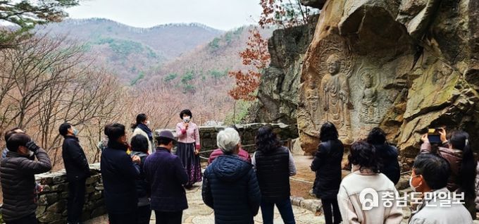 단체 관광객들이 서산9경인 서산 용현리 마애여래삼존상을 보고 있다