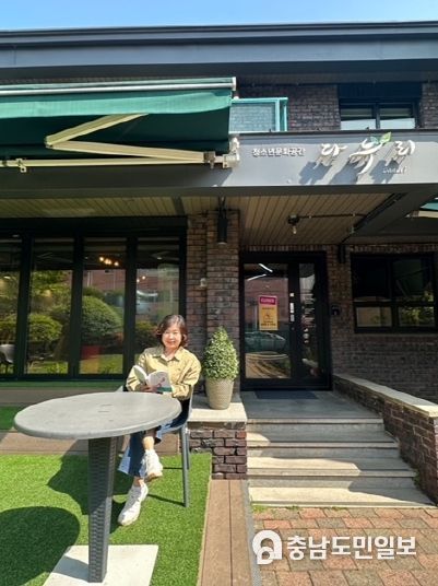 상주 작가로 선정된 양진채 작가가 청소년문화공간 다누리 앞에서 책을 읽고 있다.